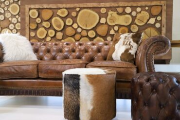 Leather sofa with cowhide pillows and stool