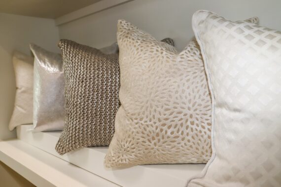 white and ivory pillows on shelf