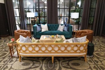 Mason Sofa with Perch Pillows, Wood and Iron Coffee Table, Hunter Green Savannah Stool, Wooden Side Table, Oxford Sofa with Perch Pillows, Henry Arm Chair, and Simple Gold Floor Lamp at Hotel Emma | Cloche Events