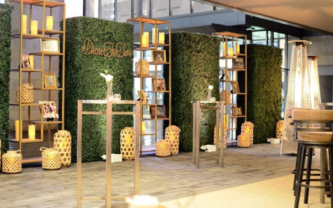 Rattan lanterns, boxwood walls, and gold shelves create a beautiful display at a rehearsal dinner in Dallas