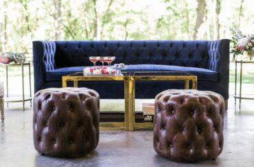 Luke Sofa | Gold & Amber Coffee Table | Brown Tufted Stool | Perch Event Decor | Luxury Furniture Rentals in Dallas Texas | Navy Blue Velvet Sofa or Couch with Modern Cubic Tables and Brown Leather Tufted Stools