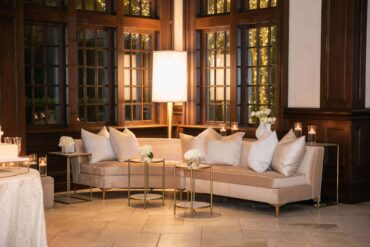 Charlotte Banquette with Marble Accent Tables, Rectangular Marble Accent Table, Marble Console Table, and Giant Gold Lamp at Dallas Country Club | Garden Gate Floral
