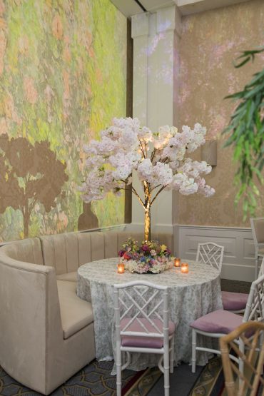 Sadie Banquette- Curved with White Gracie Dining Chairs with Lilac Cushion at The Arts District Mansion | Garden Gate Floral