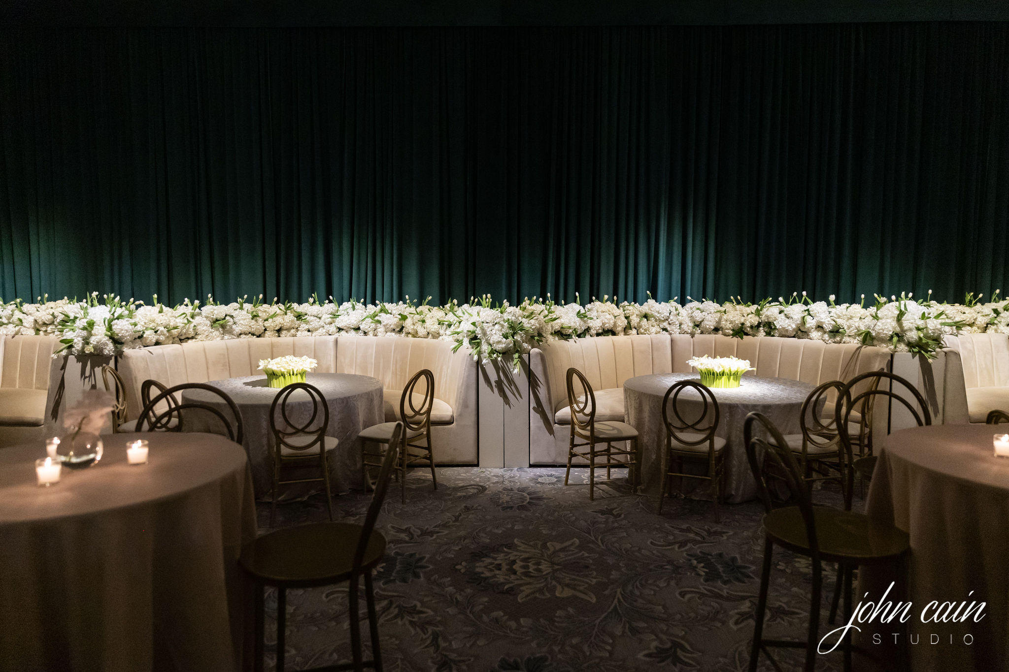 Elegant winter wedding furniture rentals with cream banquettes, round tables, and white floral arrangements.